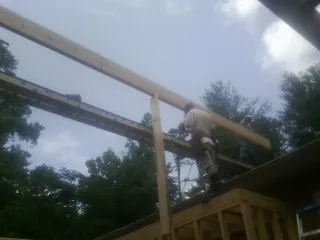 Carpenter setting a ridge beam over a new addition frame — Ice Dam Removal by Roofing Brothers in Stony Brook
