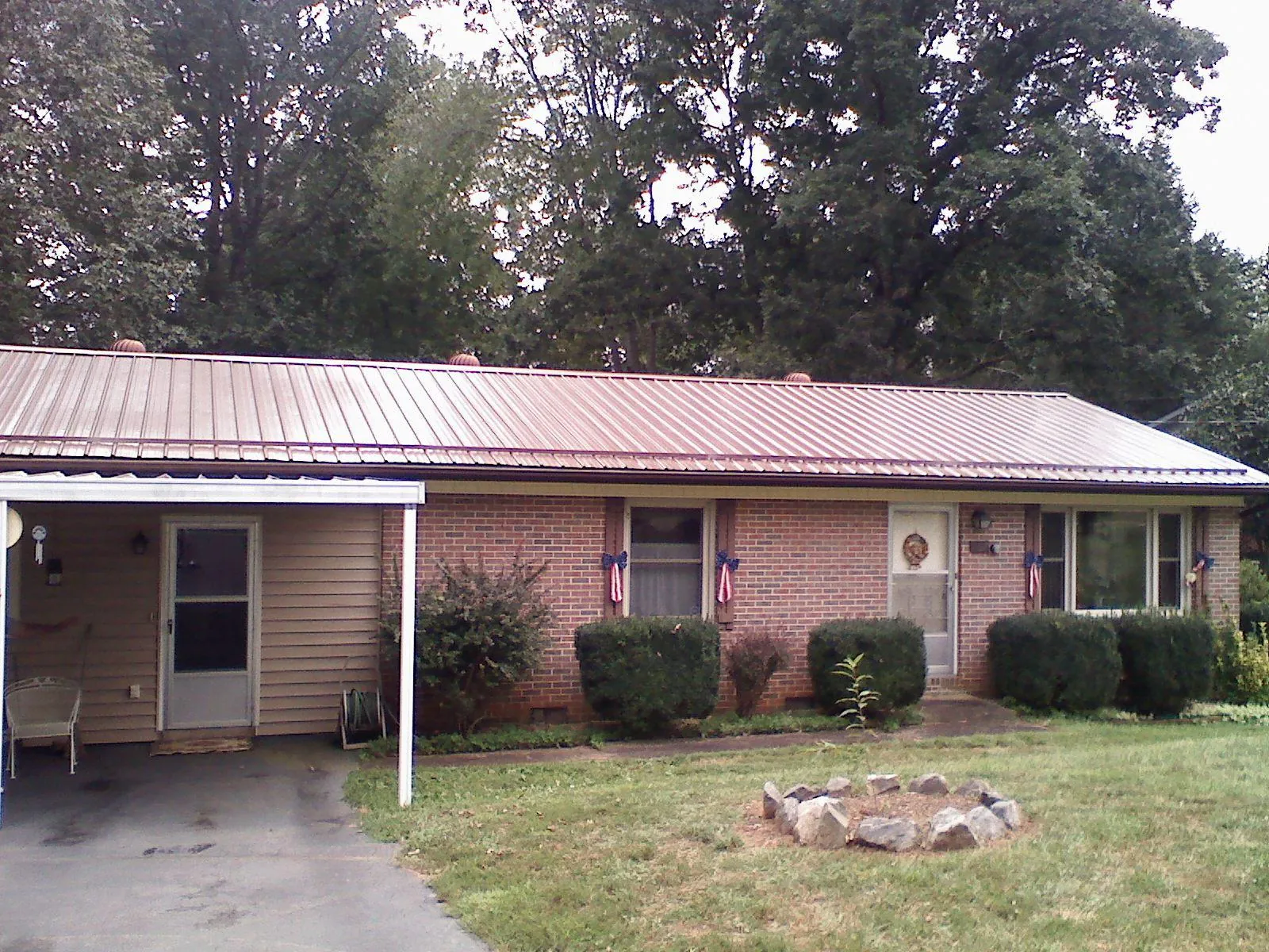 Bronze metal roof and carport on a brick ranch home — Roof Repair work by our crew in Stony Brook